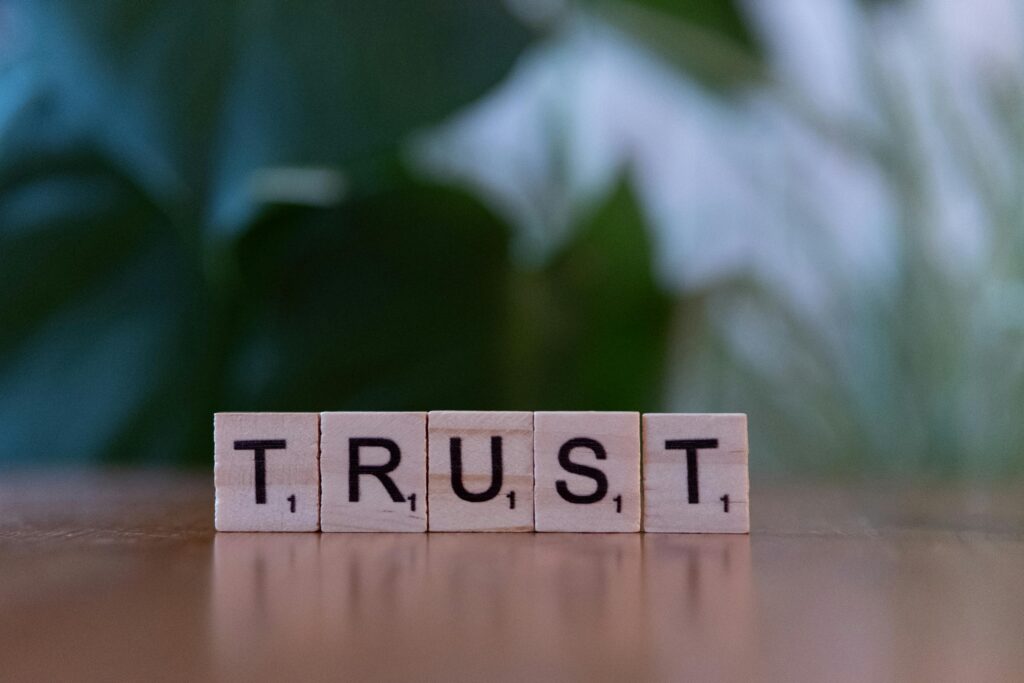 Wooden letter tiles spelling TRUST on a wooden surface, symbolizing integrity and values.